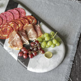 Tabla Kimaya de mármol combinado con asas de latón, servida con carnes frías